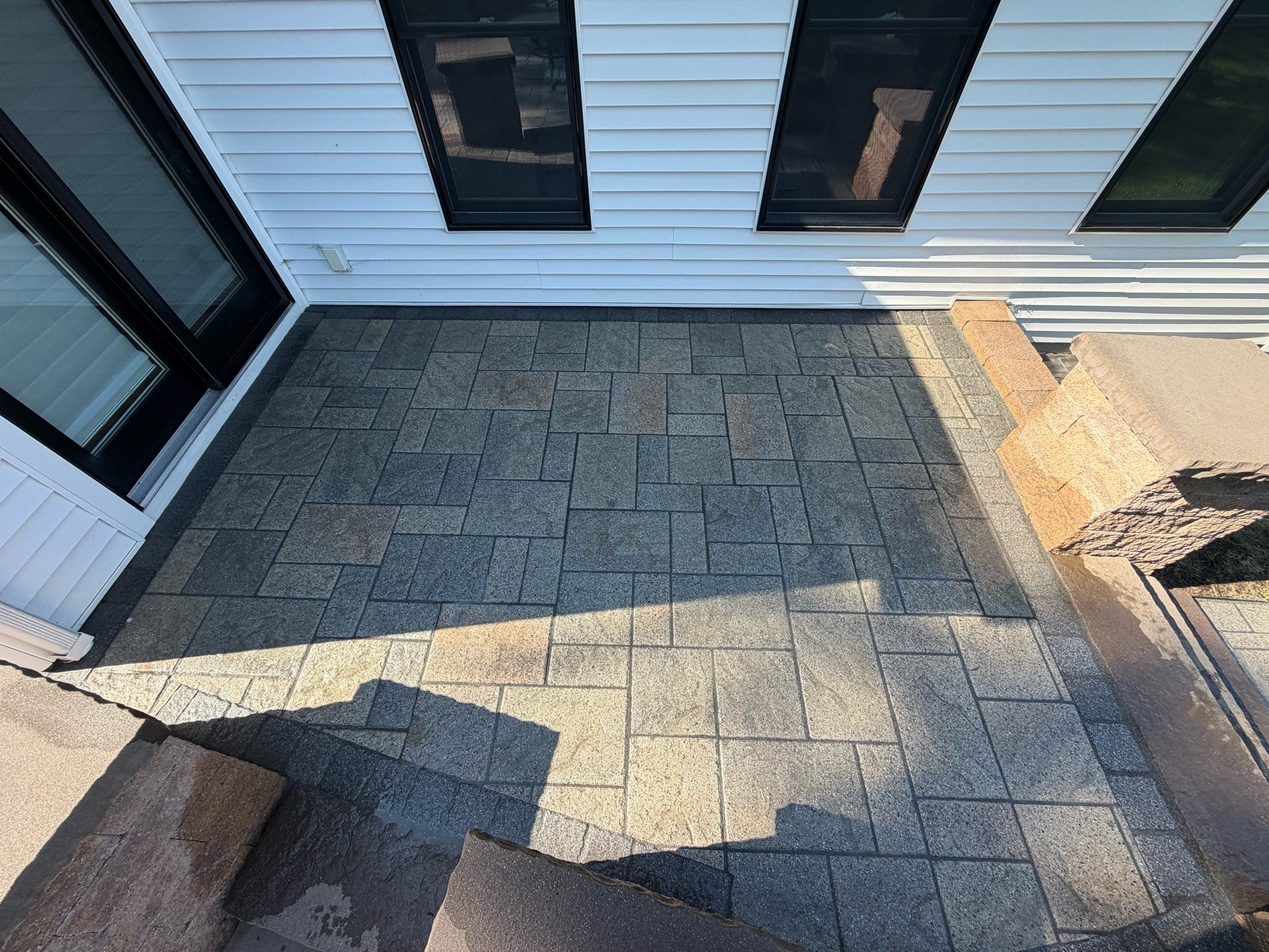 Paver patio restoration — moss and old polymer sand removed, releveled, regraded, new polymer sand and clear coat (After 1)